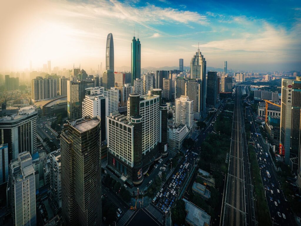 Aerial view of contemporary megapolis with tall modern glass buildings against cloudy sky