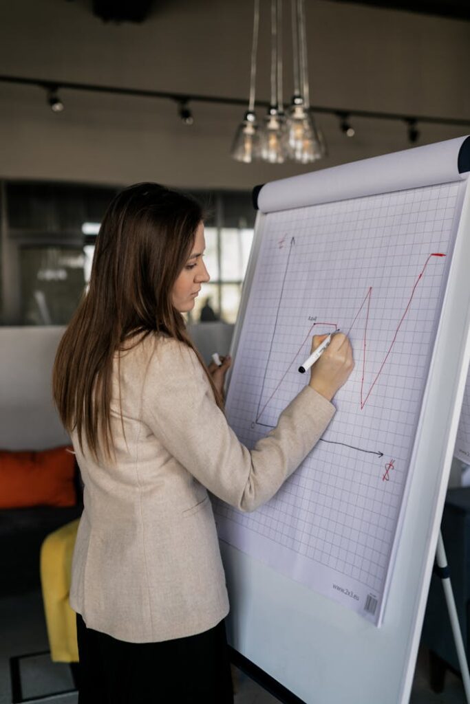 Woman in a Beige Blazer Writing a Graph